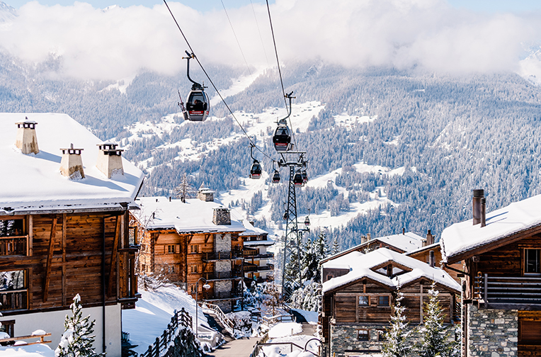 Cable cars passing over snow covered chalets